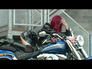 Red-haired biker in gripping striptease
